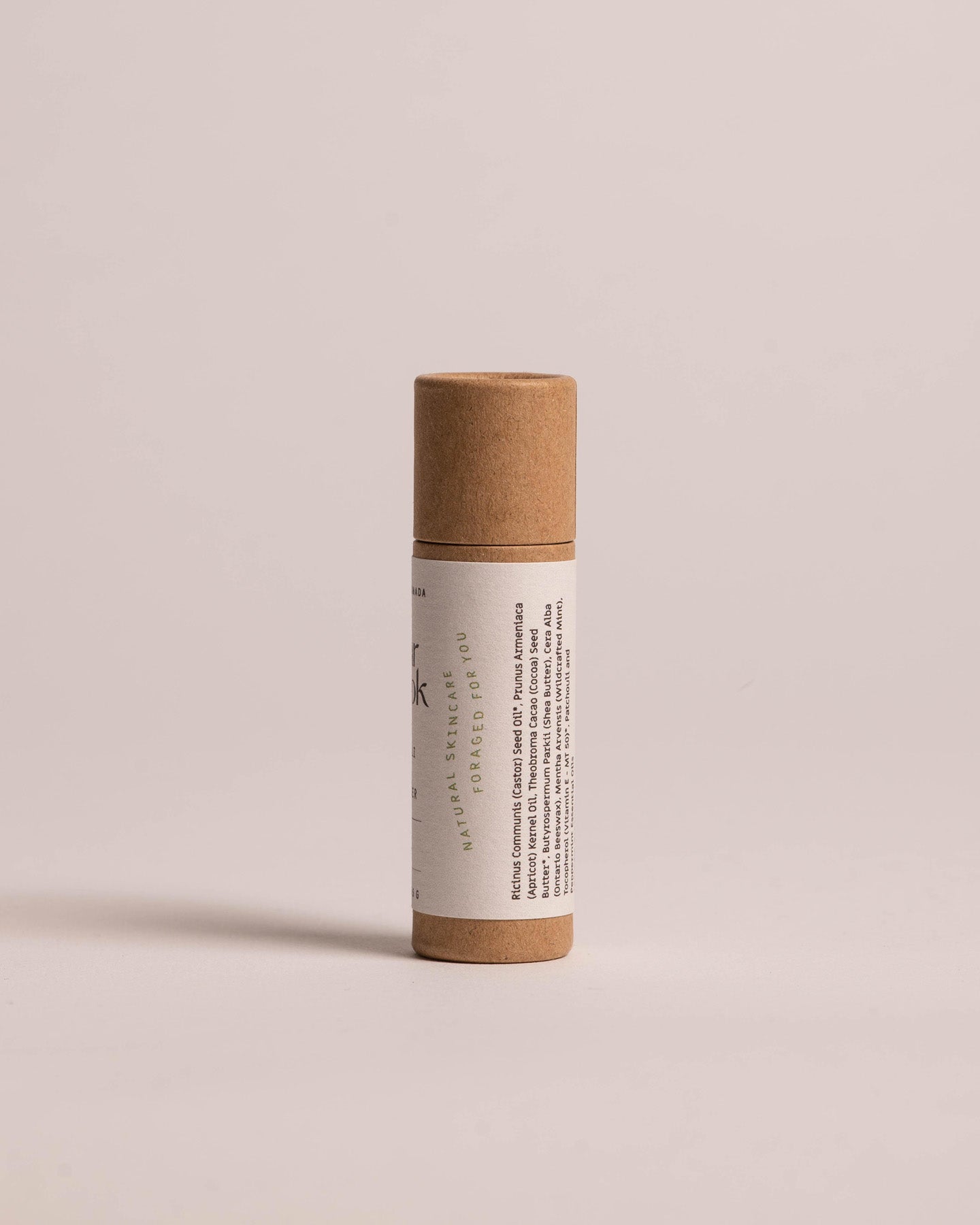 Patchouli Mint Lip Butter | The Cedar Nook in a kraft compostable tube showing white label side angel, and green logo that reads Natural Skincare Foraged For You